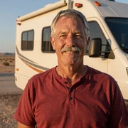 Thomas, a 63-year-old retired firefighter and Dremeet member from Arizona, smiling beside his motorhome at golden hour