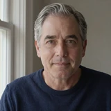 Alan, a 63-year-old widowed Dremeet member from Missouri in a navy sweater near a bright window