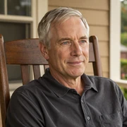 James, a 62-year-old widowed Dremeet member from Texas, smiling thoughtfully on a porch rocker in afternoon light